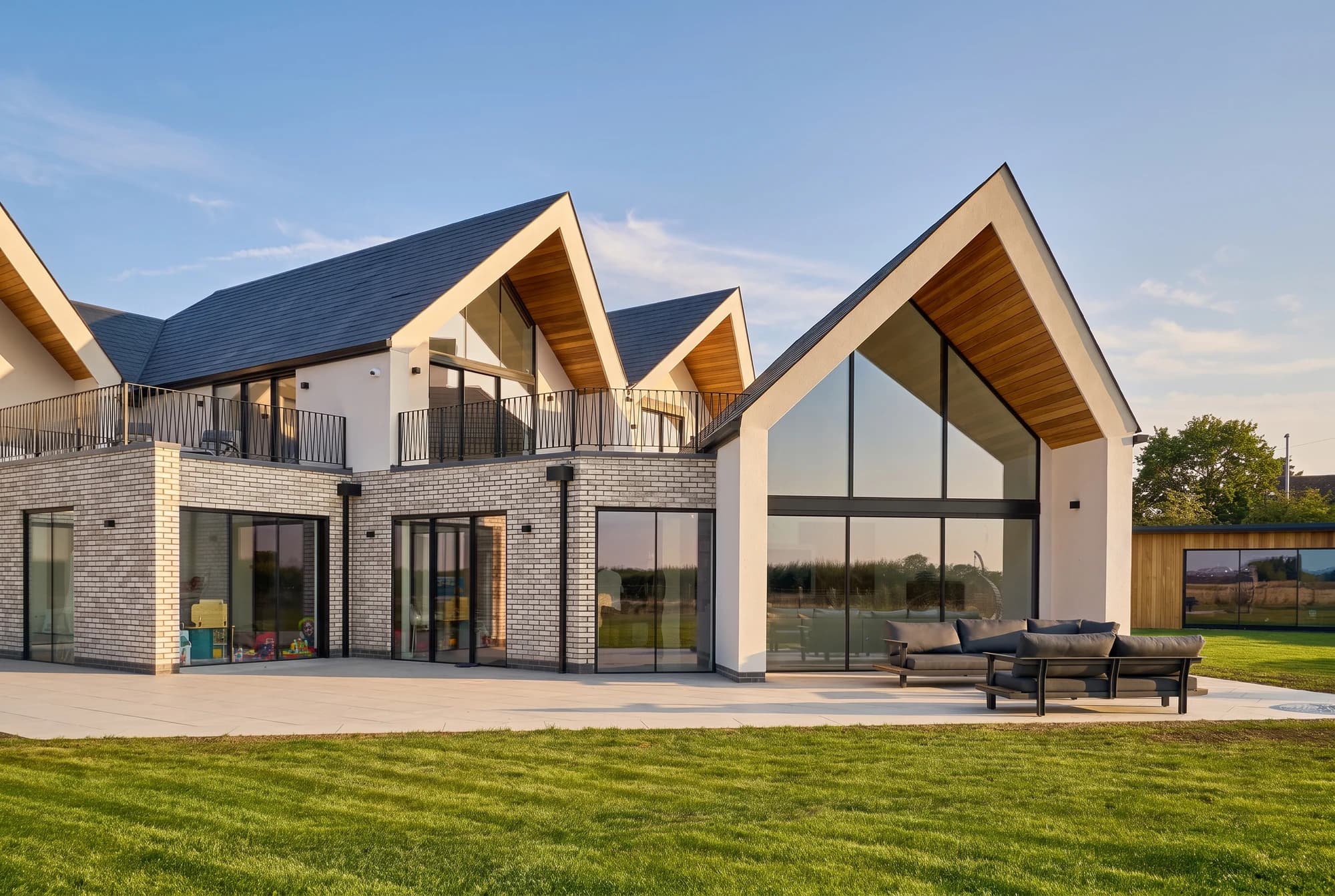 Garden elevation with glazed gables and outdoor seating
